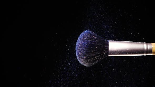 Make Up Brush with Colored Blue Powder at Black Background Slow Motion