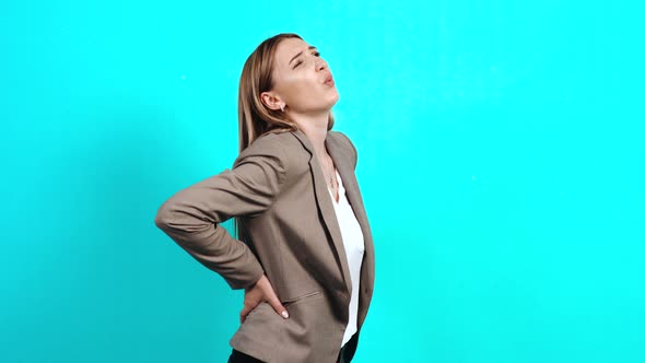 Profile Portrait of Young Businesswoman in Suit, Massaging Her Numb Spine