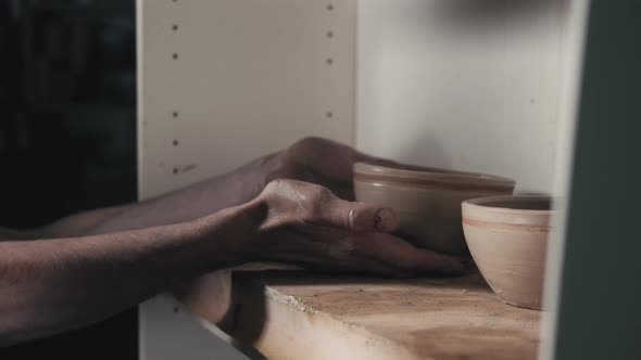 Hands of the Master Potter and Vase of Clay on the Potter's Wheel Closeup