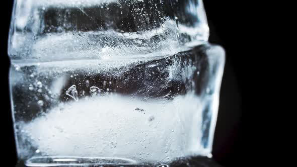 Ice Melts and Rotates on a Black Background. Timelapse