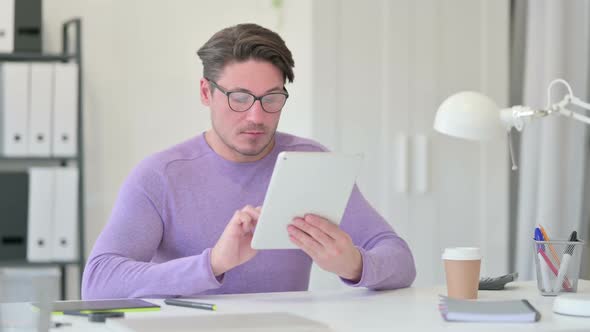 Middle Aged Man Working on Tablet