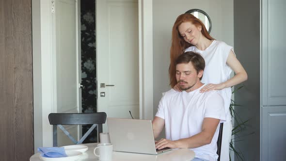 Woman Gives Massage To Her Working Husband