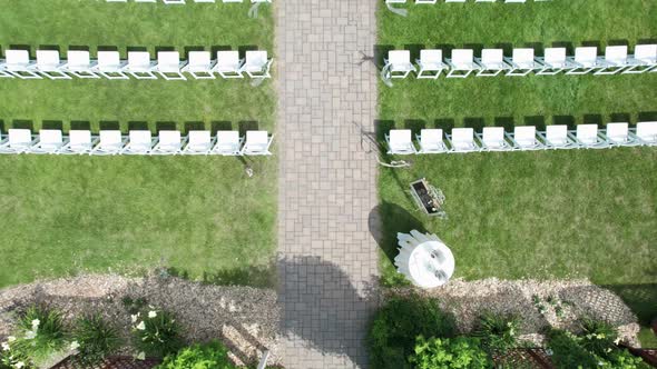 Drone shot flying over a wedding ceremony set up in a courtyard garden