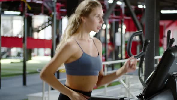 Fitness Woman Running on Treadmill in Gym. Athlete Woman Using Run Machine in Fitness Center