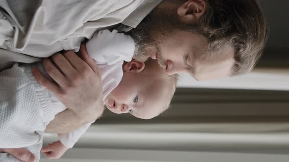 Vertical View Closeup Father Bearded Dad Holding Little Daughter Son Child Newborn Infant in Looking