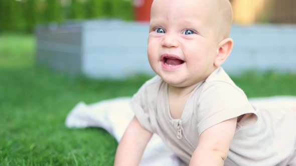 Closeup Portrait Funny Face Infant Baby Lying on Green Grass Outdoor Sunny Day