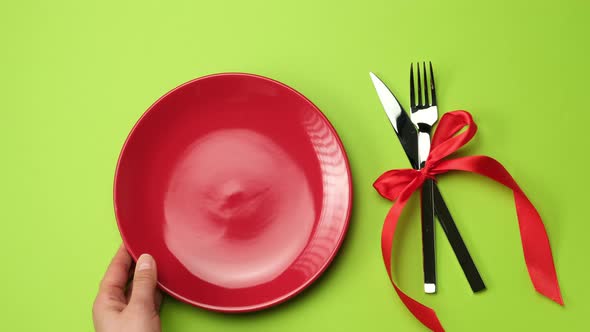 red round plate, knife with fork and Christmas decor 