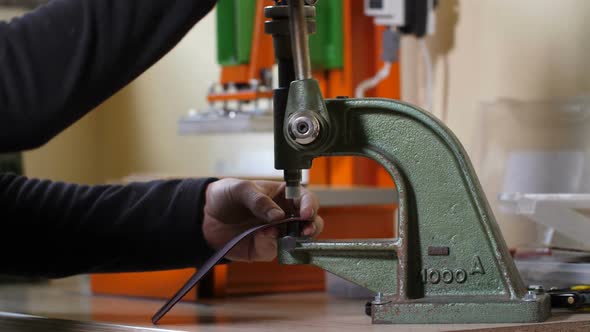 Hands of Craftsman Inserting Rivet Into Leather