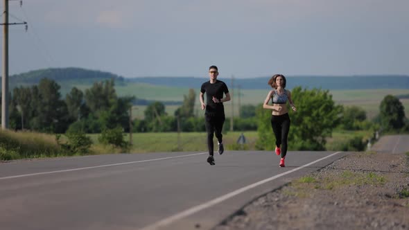 Couple Running on Asphalt Road