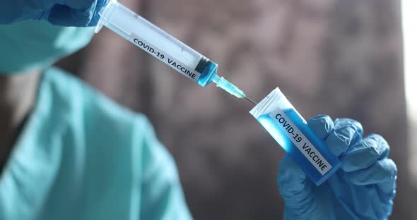Doctor holding a syringe with the coronavirus COVID-19 vaccine
