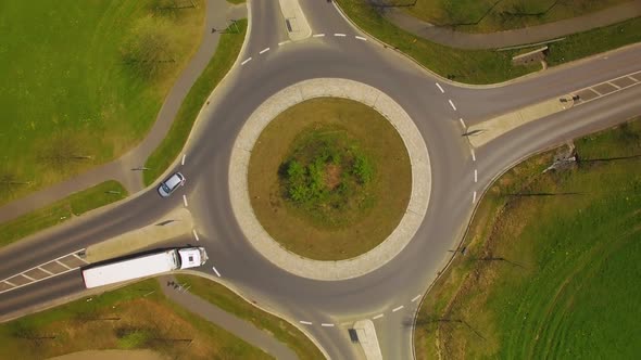 Aerial footage of a trailer truck travelling, making  a dangerous swerve in a roundabout.