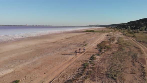 Group of cyclists ride on bike along coastline of Kuyalnik estuary. 