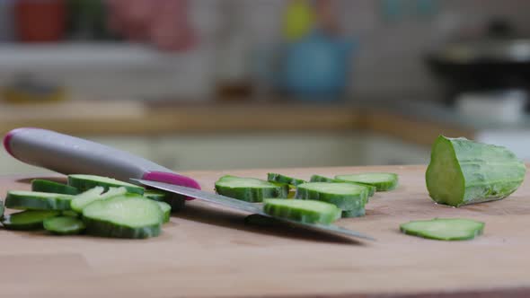 Slices Cucumber And Knife On The Table In Kitchen