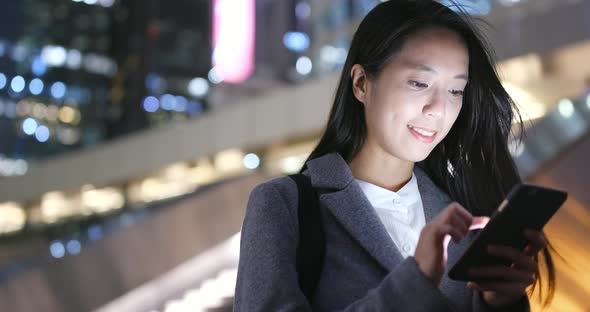Business woman use of mobile phone in city at night