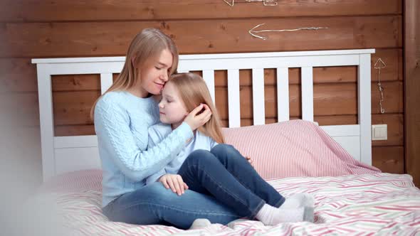 Young Caring Mother Hugging and Kissing Her Little Daughter Having Best Feeling Full Shot