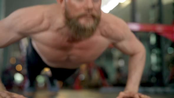 Steady Shot of a Male Athlete Doing Clap Push Up Exercises in a Gym