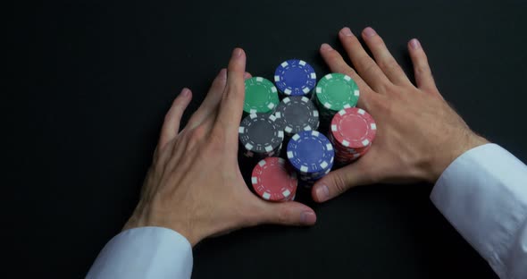 Stack Of Poker Chips And Two Hands On Table