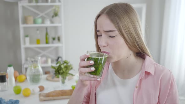 Portrait of Unhappy Young Caucasian Woman Drinking Herbal Detox Cocktail