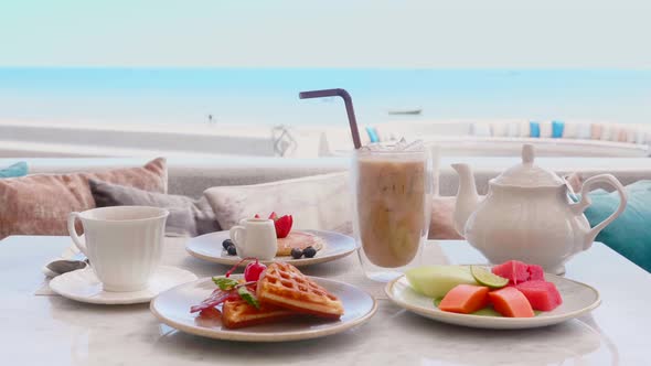 Breakfast on Table with Sea View Iced Coffee Teapot Belgian Waffles Pancake