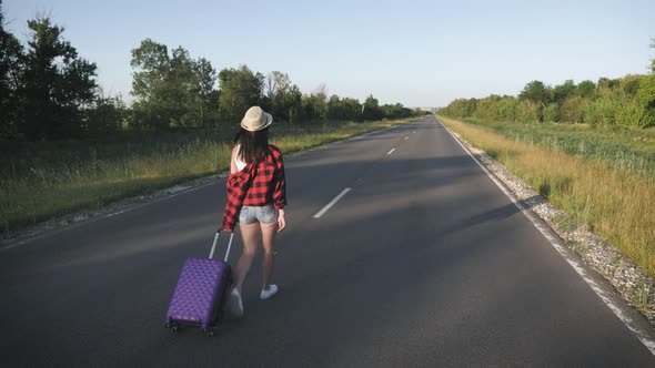 Traveler Woman with Suitcase on Road To Travel. Concept of Travel.