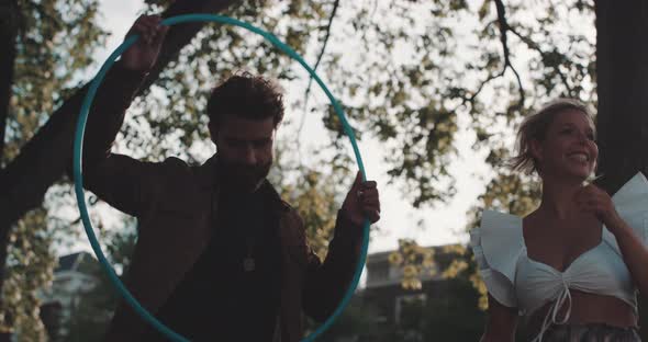 Woman passes Hula Hoop to man