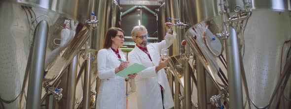 Food technologists taking beer sample