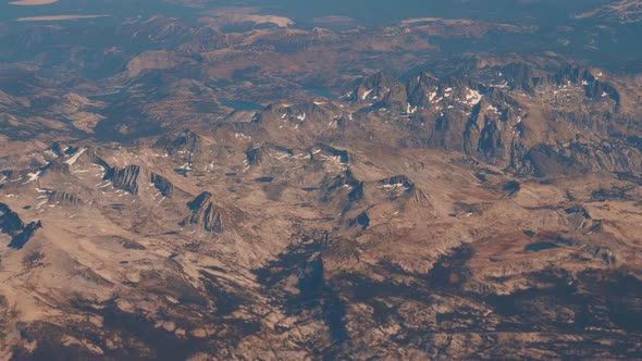 Aerial View From Plane Flying On Altitude To Mountain With Snow And Rock Massif