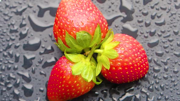 Top Ciew  Strawberry Covered with Water Droplets are Spinning on a Wet Table
