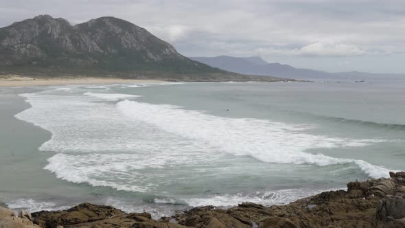 Punta Canton amazing landscape view with mountain, beach and surfers on the atlantic ocean in Spain