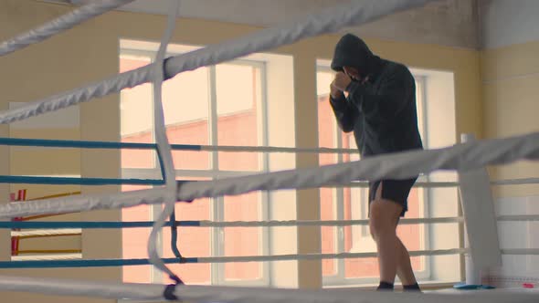 Cinematic Slow Motion Shot of a Professional Muscular Man is Practicing Shadow Boxing Workout in a