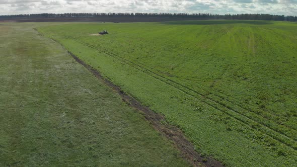 Tractor Spreads Fertilizer on Farmland
