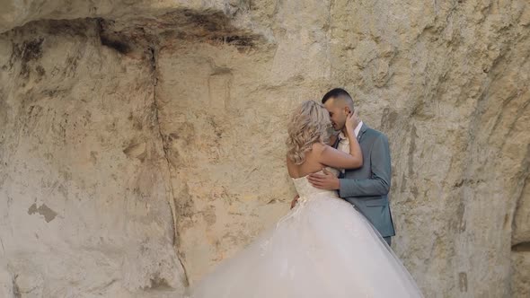 Wedding Couple Standing Together on a Mountainside. Newlyweds. Groom and Bride