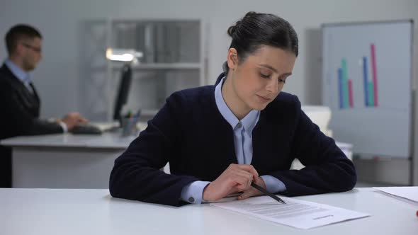 Flirty Female Manager Reading Document and Smiling at Camera, Romantic Mood