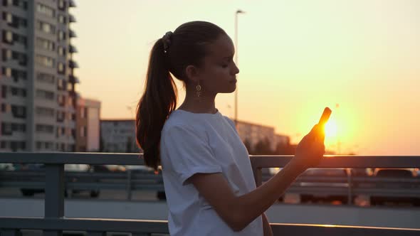 Addicted Young Teenage Girl with Ponytail Holds Smartphone