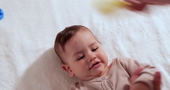 Mother Combing Tiny Hairs on Her Newborn Baby's Head As She Wakes Up