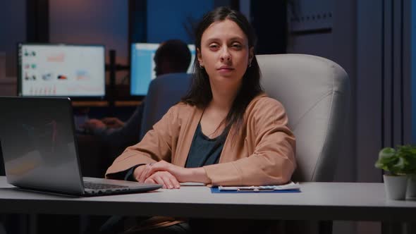 Portrait of Smiling Businesswoman Looking Into Camera While Sitting at Desk