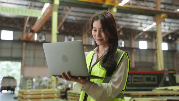 Portrait of Asian female industry worker working in factory warehouse.