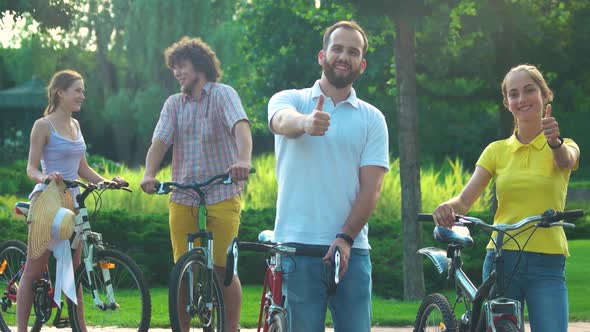 Couple of Young Cyclists Showing Thumbs Up