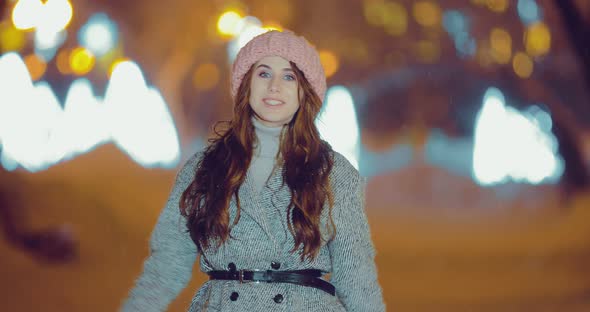 Happy Woman Walking on the Street at Night in Winter