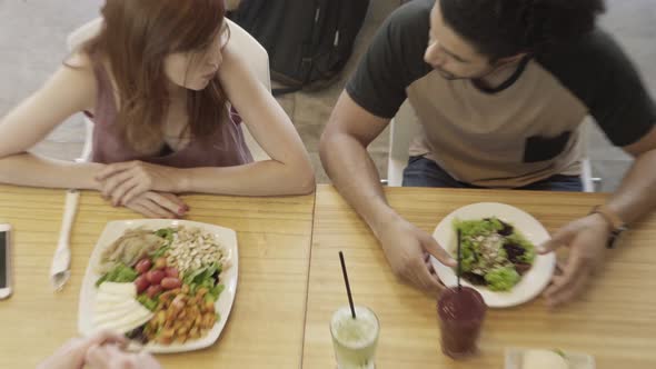 Friends chatting while having meal in restaurant together