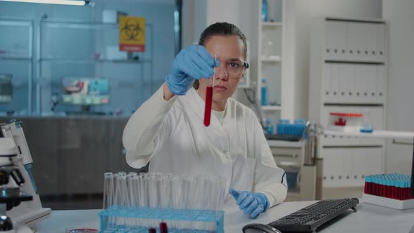 Microbiologist Analyzing Test Tube with Red Substance in Science Lab