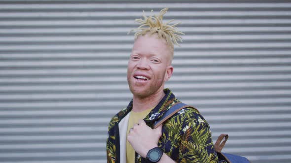 Portrait of smiling albino african american man with dreadlocks looking at camera