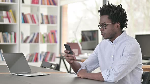 African Man Using Smartphone at Work