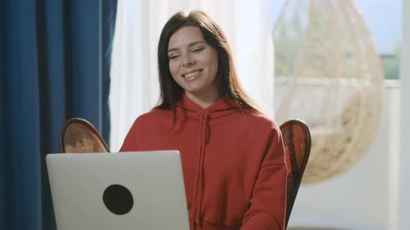 Happy brunette millennial woman making video call to her friends