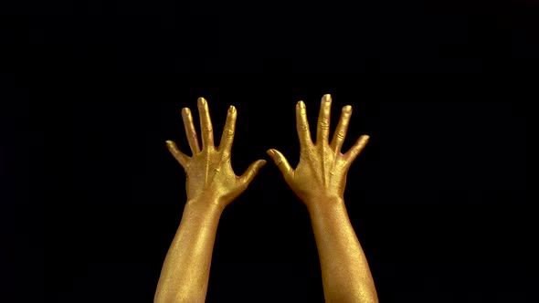Nice Footage of Woman Gold Hands Gesture. Black Background. Hands in Gold Color Paint on Black