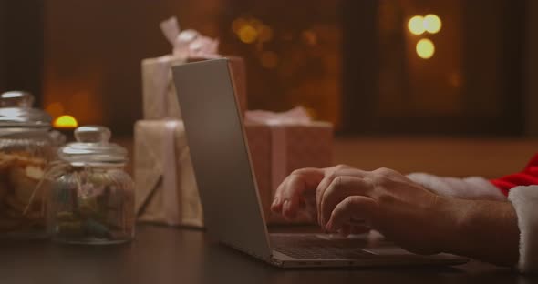 Santa's Hands Are Typing on a Laptop Keyboard