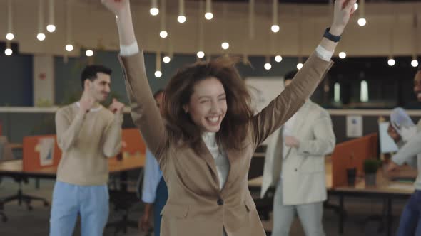 Funny Caucasian Businesswoman Dancing with Colleagues Celebrating Corporate Success Enjoy Office