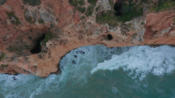 Sensational Top Down Drone Aerial View of Turquoise Water Waves Crashing Against Cliff Coast Lagos