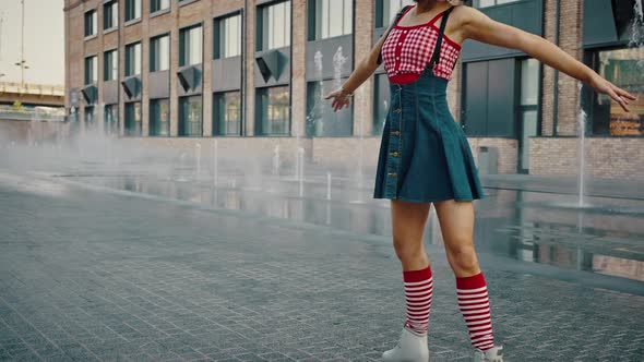 Young Beautiful Pin Up Woman in Bright Clothes Rollerblading on Roller Skates Outdoor Dancing Near