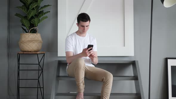 Man Using Mobile Phone Sitting on Stairs